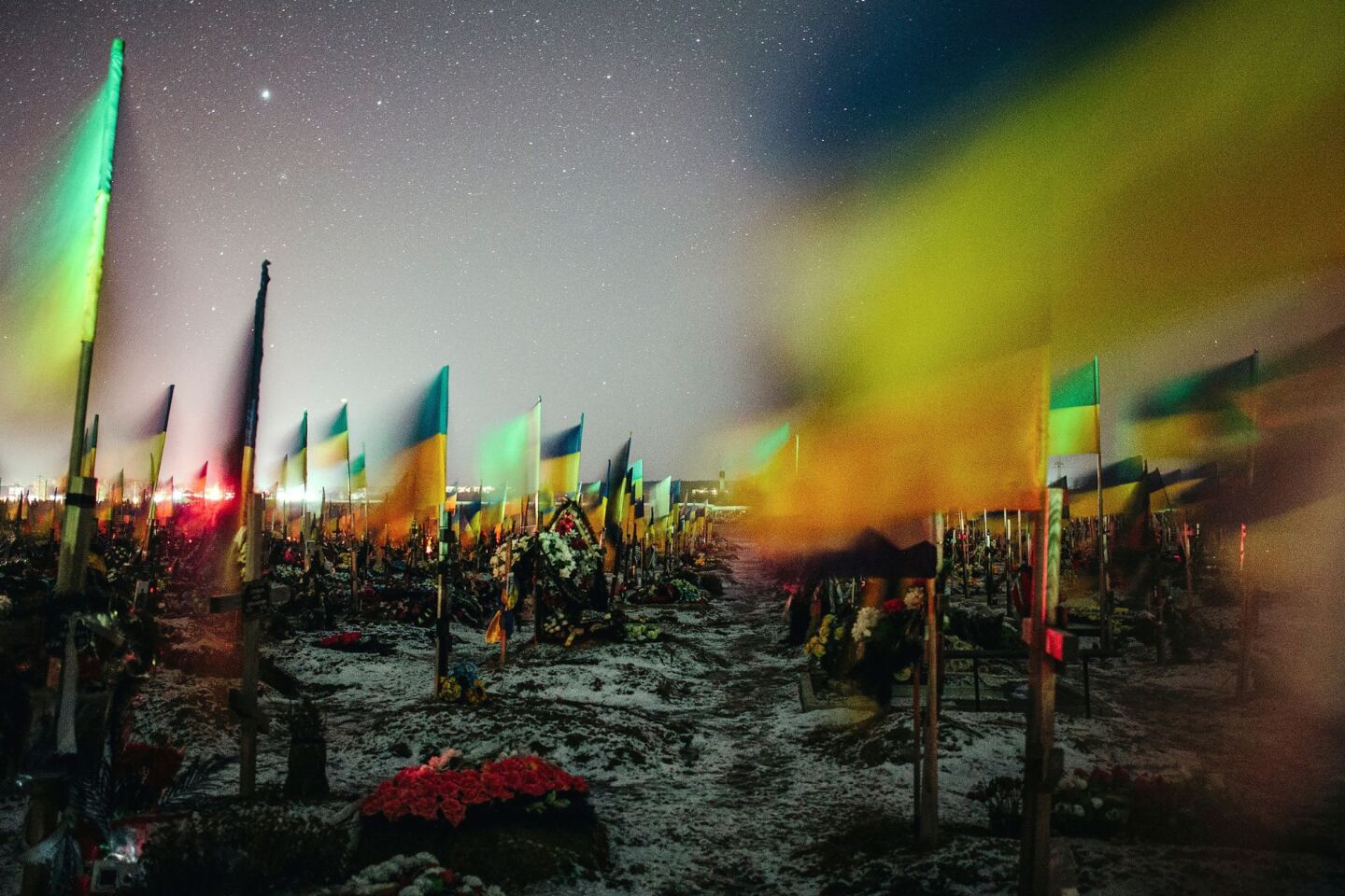 Ουκρανικές σημαίες κυματίζουν πάνω από τους τάφους Ουκρανών στρατιωτών σε ένα στρατιωτικό νεκροταφείο στο Χάρκοβο στις 22 Φεβρουαρίου 