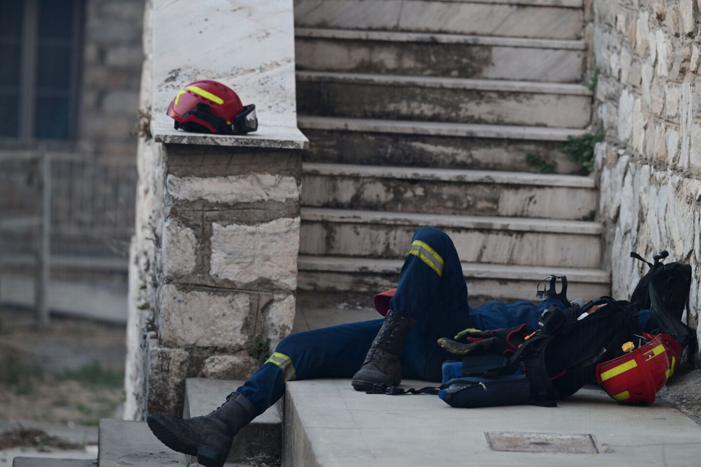 Αποκαμωμένος πυροσβέστης παίρνει λίγες ανάσες ξεκούρασης