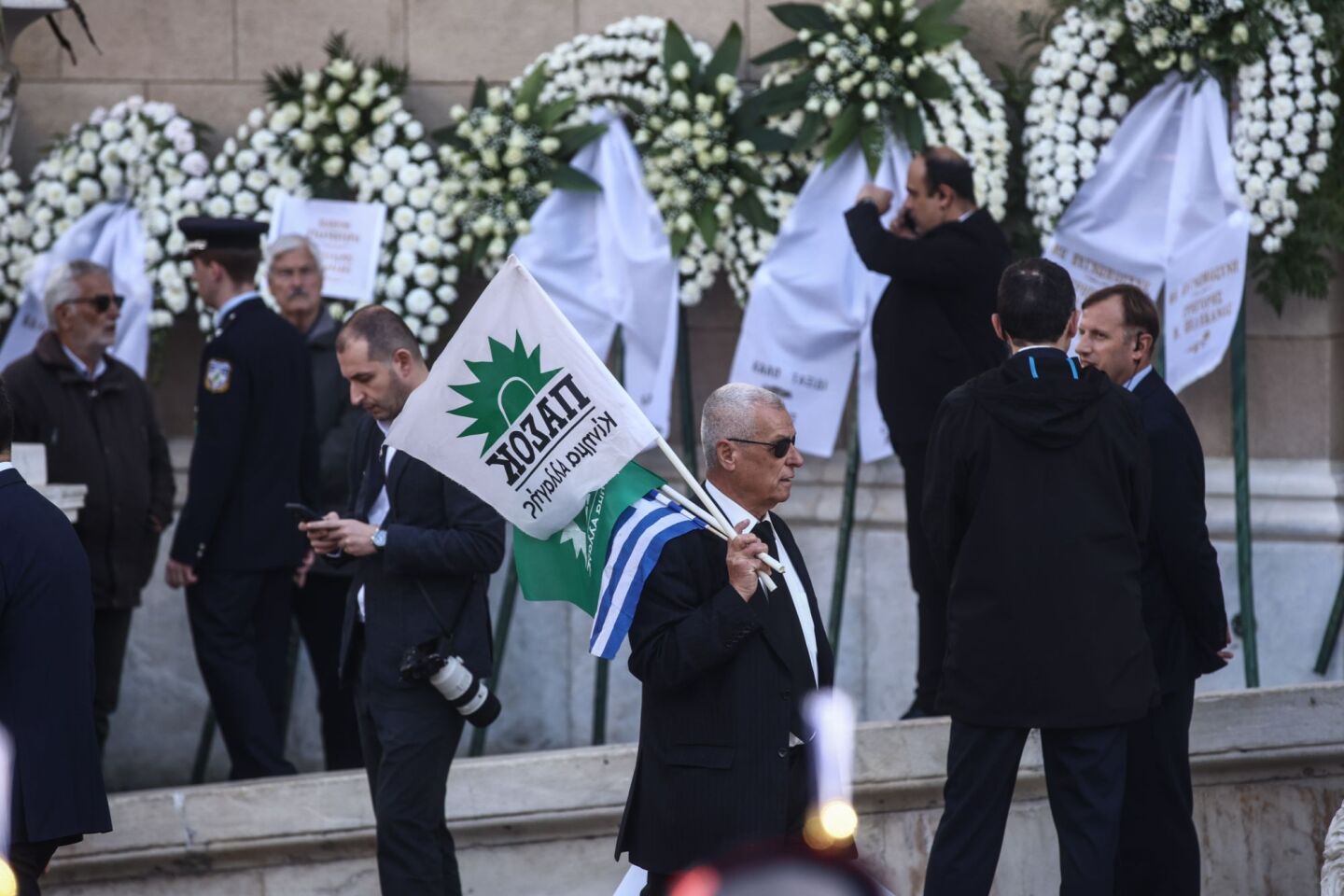 Πολίτες έξω από τη Μητρόπολη Αθηνών κρατώντας σημαίες του ΠΑΣΟΚ