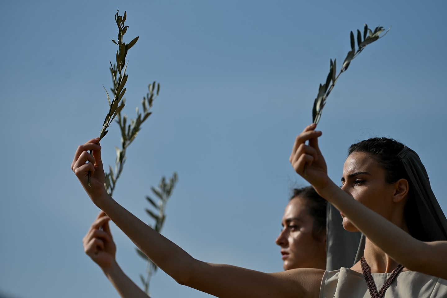 Γυναίκες με αρχαιοελληνικό φόρεμα που κρατούν κλαδιά ελιάς