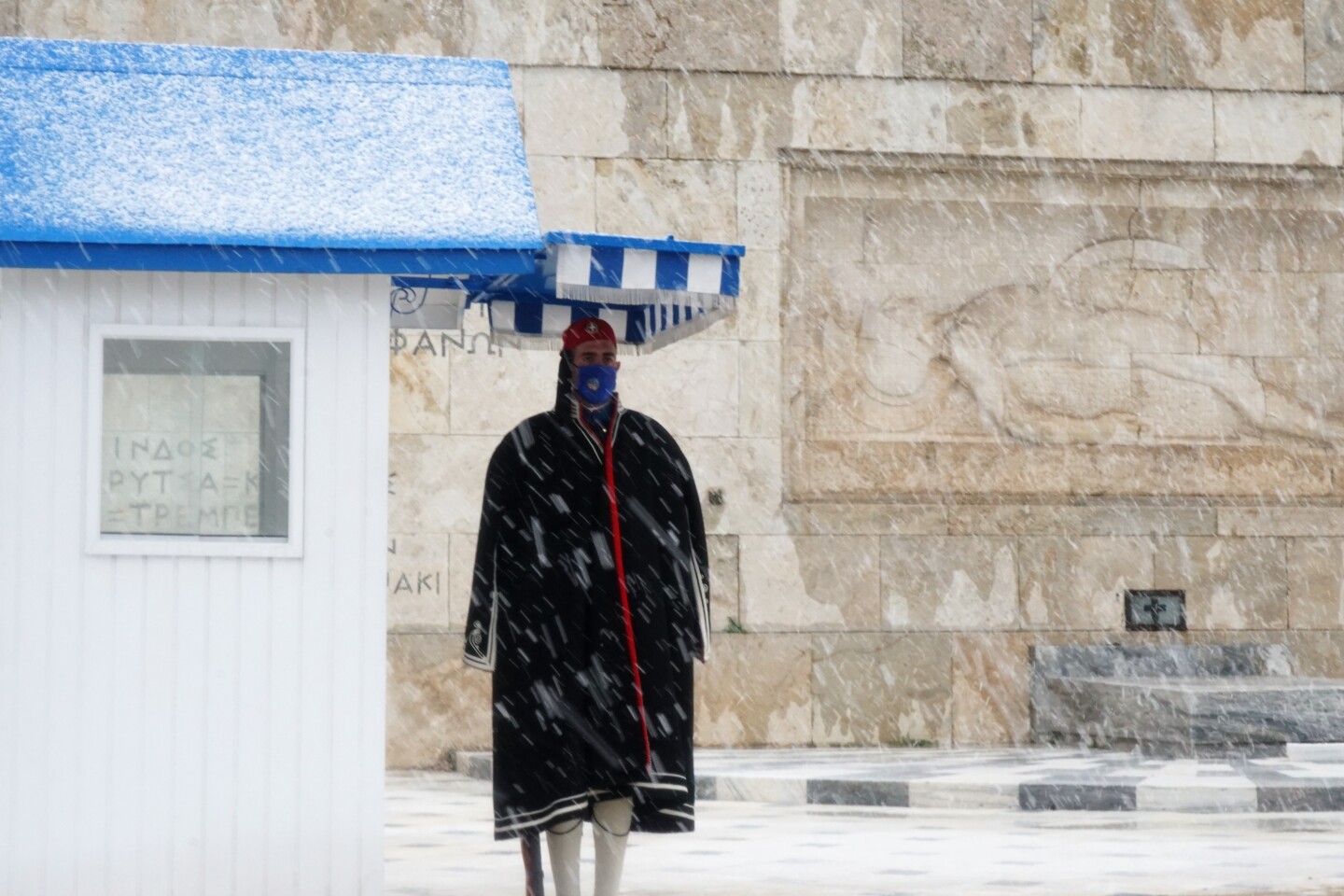 Οι Εύζωνες στέκονται στο Μνημείο του Άγνωστου Στρατιώτη παρά τις αντίξοες καιρικές συνθήκες.