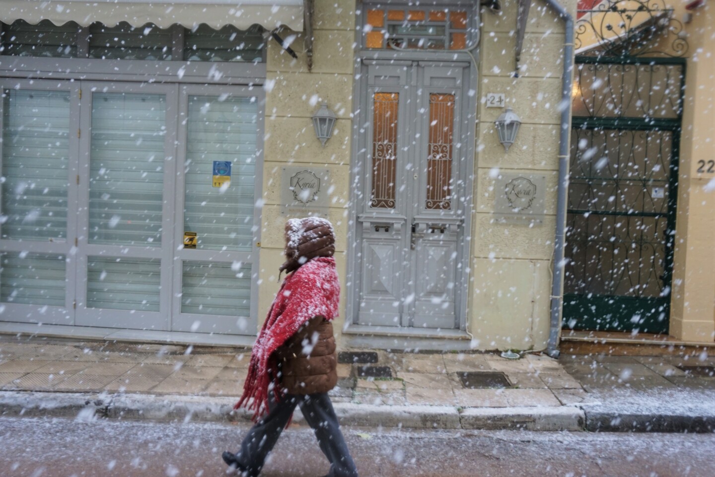 Μια γυναίκα περπατάει την ώρα που έχει ξεκινήσει μεγάλη χιονόπτωση στο κέντρο της Αθήνας. 