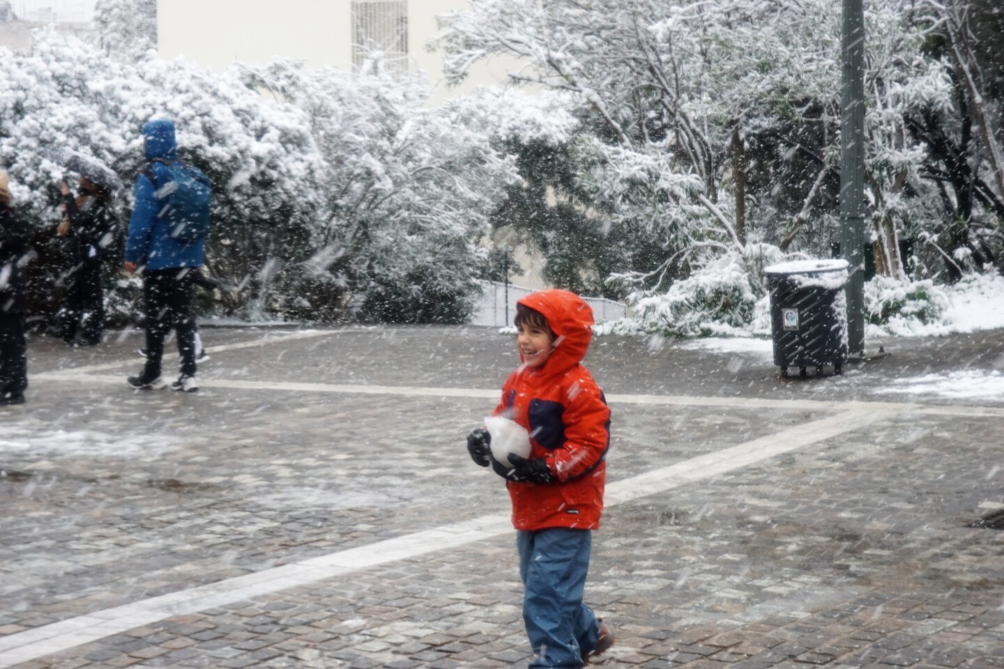 Ένα παιδί παίζει με τα χιόνια. 