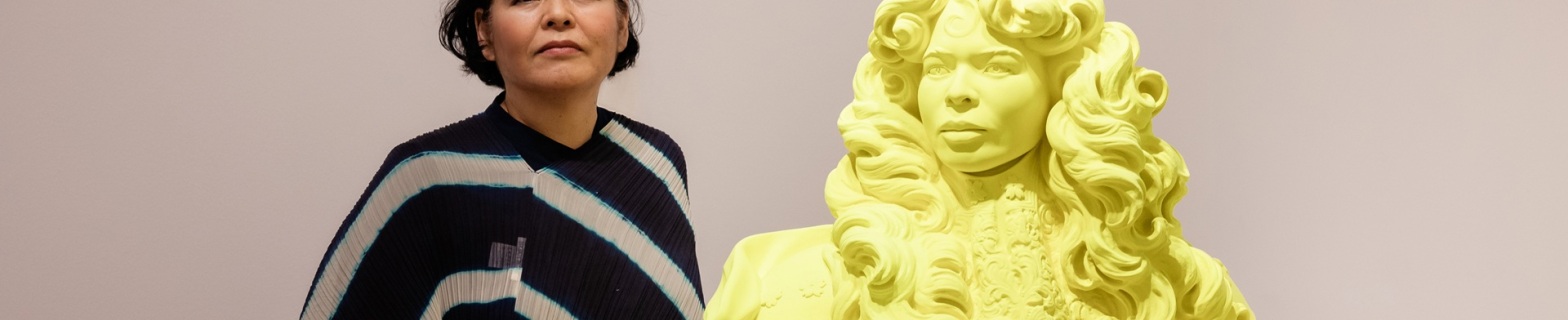 Η Κιμίκο Γιοσίντα ποζάρει δίπλα στο γλυπτό που απεικονίζει τον βασιλιά Λουδοβίκο