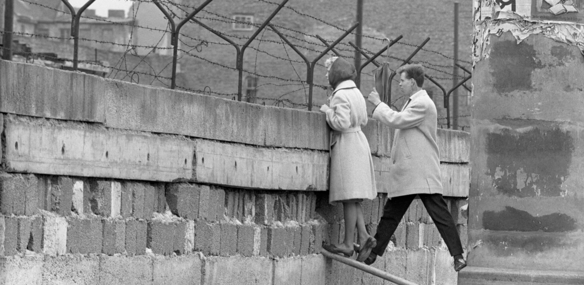 21 Απριλίου, 1962 | Μια νεαρή γυναίκα, συνοδευόμενη από τον φίλο της, στέκεται στην κορυφή του Τείχους του Βερολίνου για να μιλήσει με τη μητέρα της στην πλευρά του Ανατολικού Βερολίνου