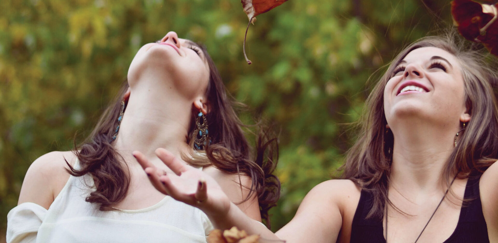 Κορίτσια παίζουν με πεσμένα φύλλα