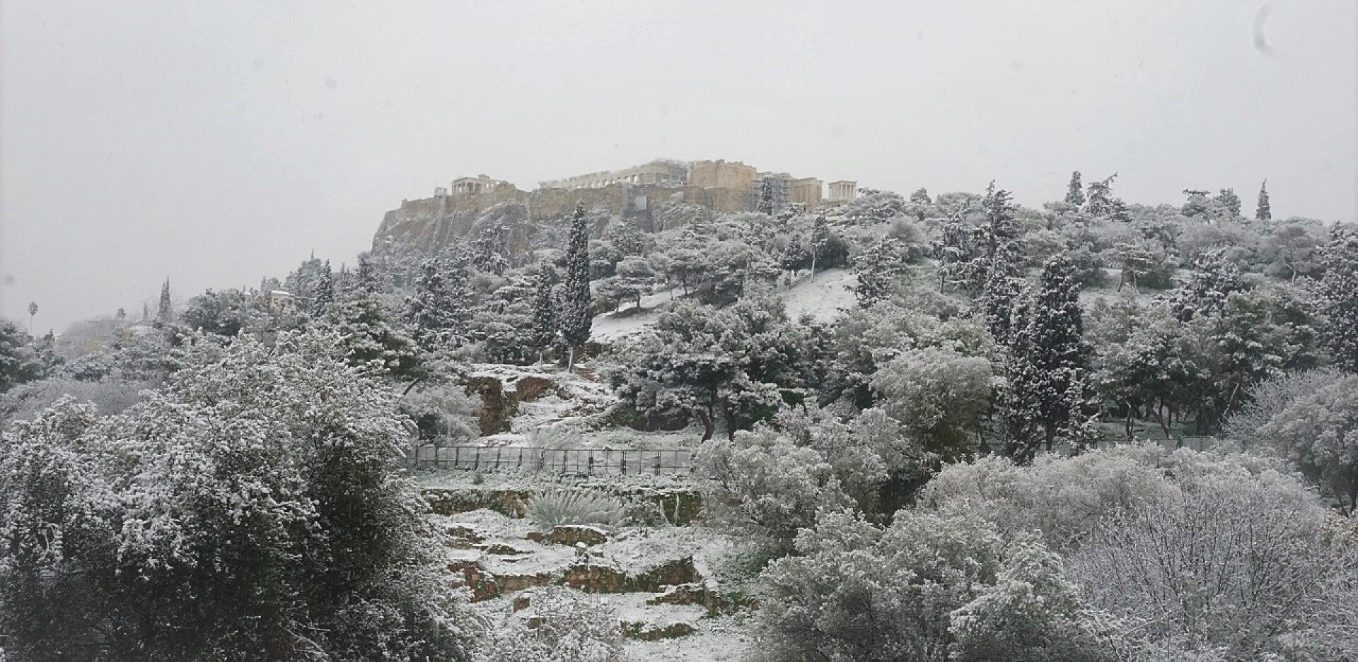 Λευκό τοπίο στο κέντρο της Αθήνας με φόντο τη χιονισμένη Ακρόπολη.
