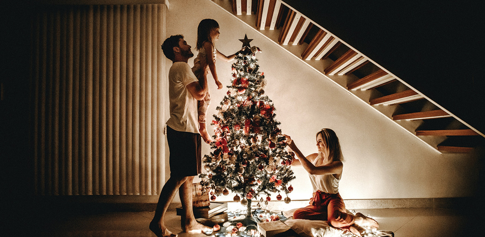 Τριμελής οικογένεια στολίζει το χριστουγεννιάτικο δέντρο 