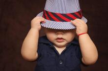 Παιδί φορά καπέλο που κρύβει τα μάτια του - Το κρατά με το χέρι του