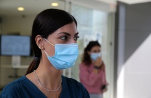 Γυναίκα φορά μάσκα προστασίας από τον κορωνοϊό σε εσωτερικό χώρο