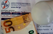 Λογαριασμός της ΔΕΗ με χαρτονόμισμα των 50 ευρώ και μία λάμπα