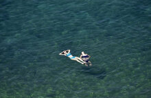 Λουόμενες στην παραλία απολαμβάνουν τη θάλασσα