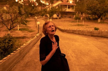 Ηλικιωμένη σε απόγνωση, καθώς εγκαταλείπει το σπίτι της που τυλίγεται στις φλόγες, στο χωριό Γούβες, στη βόρεια Εύβοια