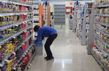 Υπάλληλος σε σούπερ μάρκετ τοποθετεί ταμπελάκι για το «καλάθι του νοικοκυριού»