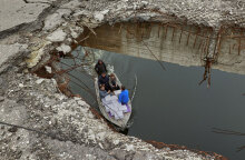 Στην Ουκρανία μέλη του Ερυθρού Σταυρού μεταφέρουν ανθρωπιστική βοήθεια, περνώντας με βάρκα κάτω από βομβαρδισμένη γέφυρα στο Χάρκοβο
