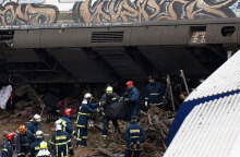 Πυροσβέστες απομακρύνουν τη σορό επιβάτη μετά τη σύγκρουση τρένων στα Τέμπη