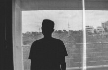 Έφηβος κοιτά από το παράθυρο