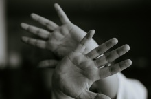 Άτομο με τα χέρια μπροστά στο πρόσωπο - Εικόνα που παραπέμπει στην ανάγκη το άτομα να προστατευτεί και να αποφύγει την επίθεση - κίνδυνο