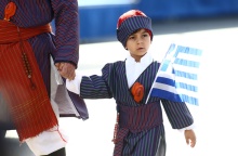 Παιδάκι με παραδοσιακή φορεσιά και την ελληνική σημαία στη στρατιωτική παρέλαση της Θεσσαλονίκης