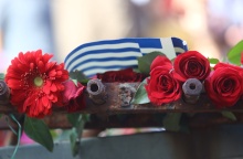 Λουλούδια και ελληνική σημαία στην ιστορική πύλη του Πολυτεχνείου