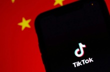 Το logo του TikTok και πίσω μία σημαία της Κίνας