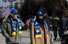 Δύο άντρες με κασκόλ και καπέλα που γράφουν Κόσοβο