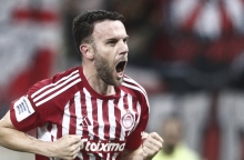 Ποδοσφαιριστής Ολυμπιακού με ερυθρόλευκη στολή πανηγυρίζει