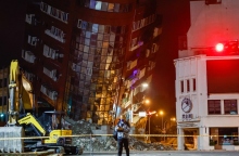 Μισογκρεμισμένη πολυκατοικία πίσω από άνδρα με μάσκα - μπάζα, κτίρια, εσκαφέας