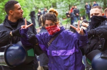 αστυνομικοί συλλαμβάνουν διαδηλώτρια