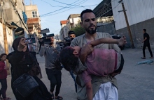 ανδρας κραταει τραυματισμένο παιδι