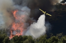 αεροπλανο της πυροσβεστικης ριχνει νερο σε δασος που φλέγεται