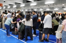 επιβατες περιμενουν στον ελεγχο αποσκευων αεροδρομιου