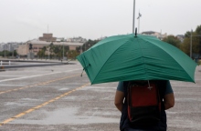 ανδρας περπαταει με ομπρελα