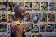 Άνδρας φωτογραφίζει τα πορτραίτα των υπολοίπων ομήρων που κρατιούνται στα τούνελ της Γάζας © ΕΡΑ/ABIR SULTAN