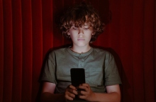 παιδι καθισμενο κραταει κινητο