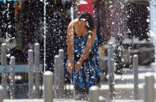 Γυναίκα δροσίζεται σε σιντριβάνι