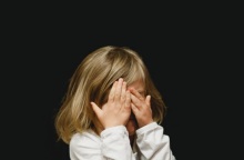 Παιδί κρύβει το πρόσωπό του - Εικόνα που παραπέμπει σε κακοποίηση