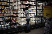 Εργαζόμενη σε σούπερ μάρκετ μπροστά από ψυγείο με γαλακτοκωμικά προϊόντα