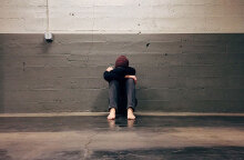 Παιδί με τα χέρια στα πόδια του κάθεται σε διάδρομο 