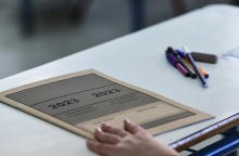Τετράδιο εξετάσεων και παραταγμένα στιλό σε θρανίο για τις Πανελλήνιες 2023