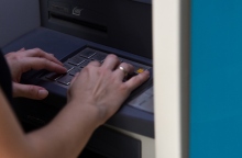 Χέρι με βέρα πληκτρολογεί σε ΑΤΜ