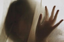 Γυναίκα πίσω από κουρτίνα