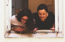 Δύο γυναίκες χαρούμενες μιλούν από το μπαλκόνι τους λόγω καραντίνας