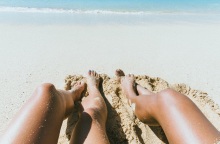 Γυναικεία πόδια στην άμμο παραλίας