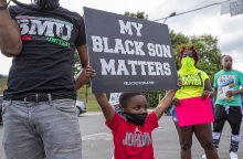 Ένα μικρό παιδί στις ΗΠΑ κρατάει πανό κατά του ρατσισμού