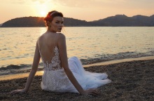 Κοπέλα με νυφικό καθισμένη στην άμμο