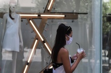 Μία κοπέλα με μάσκα και καφέ