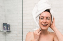 Κοπέλα με πετσέτα στα μαλλιά και το σώμα βγαίνει από το ντους