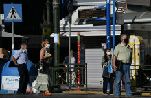 Πολίτες με μάσκα για τον κορωνοϊό περιμένουν το λεωφορείο στη στάση