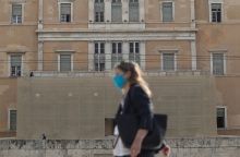 Γυναίκα που φορά χειρουργική μάσκα έξω από την Βουλή